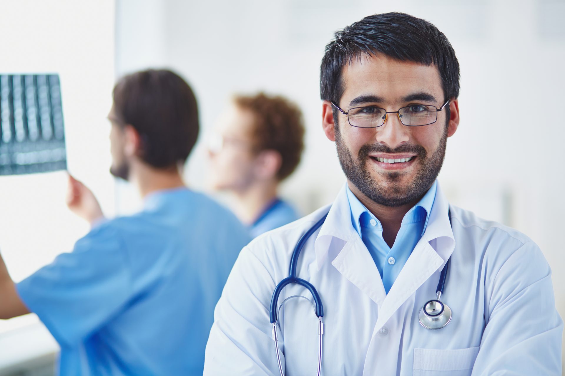 physician-with-co-workers-blurred-background